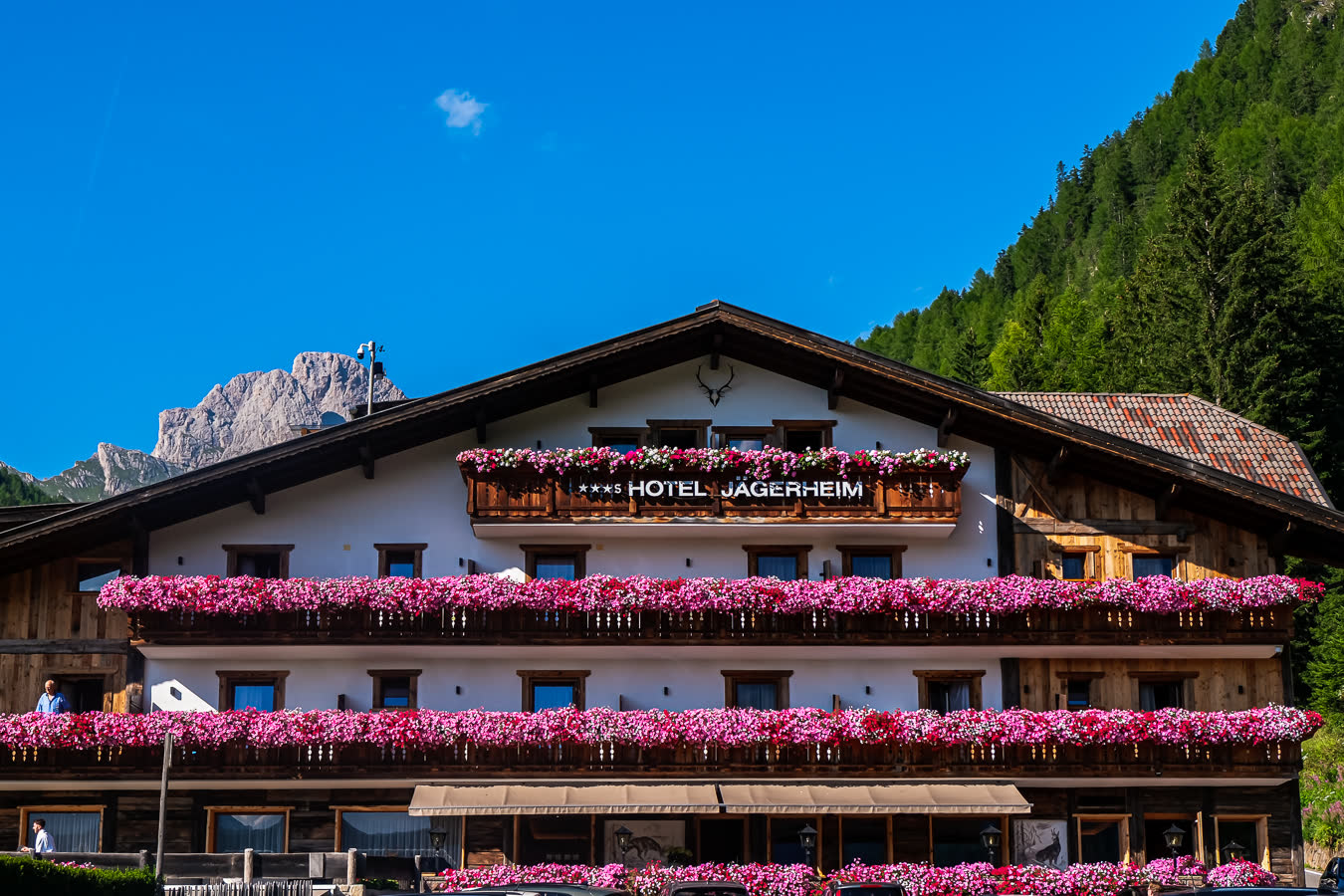 An alpine hotel with flower boxes along every balcony