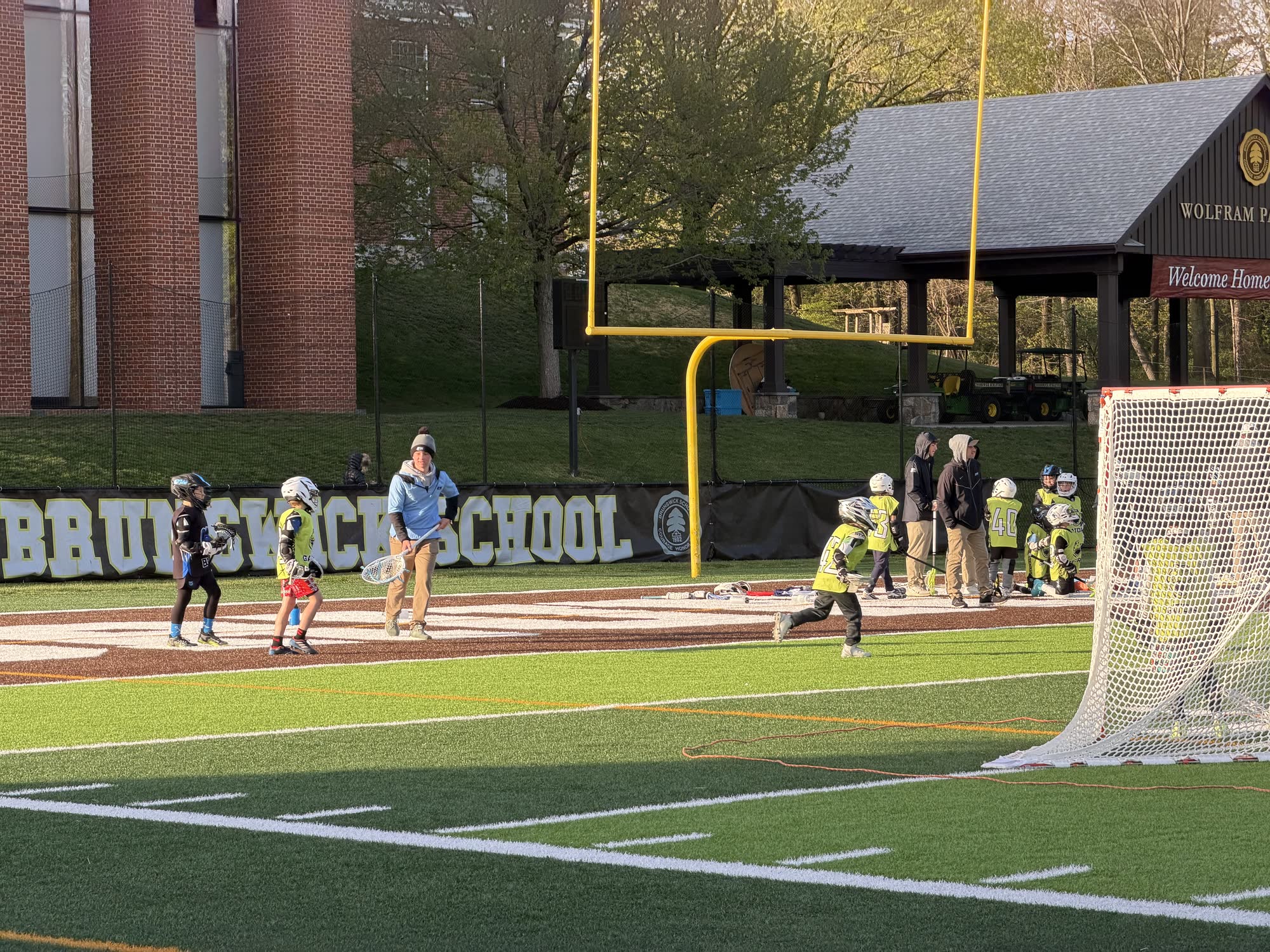 Jack Crombie coaching a youth lacrosse session on a turf field