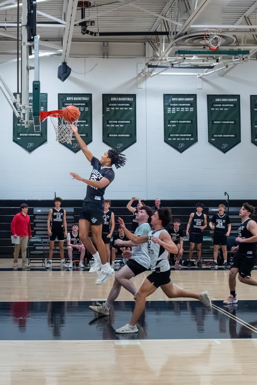 A basketball player rising to finish a layup, photographed by Jack Crombie