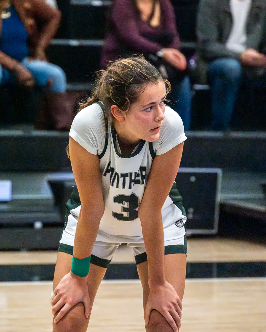 A player catching her breath with hands on knees