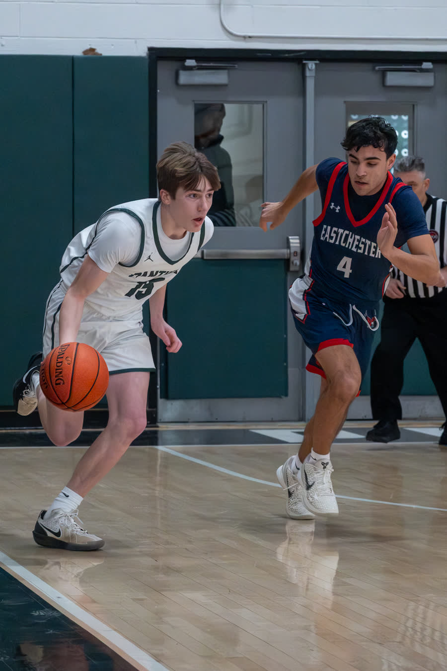 A guard driving the ball up the floor past a defender