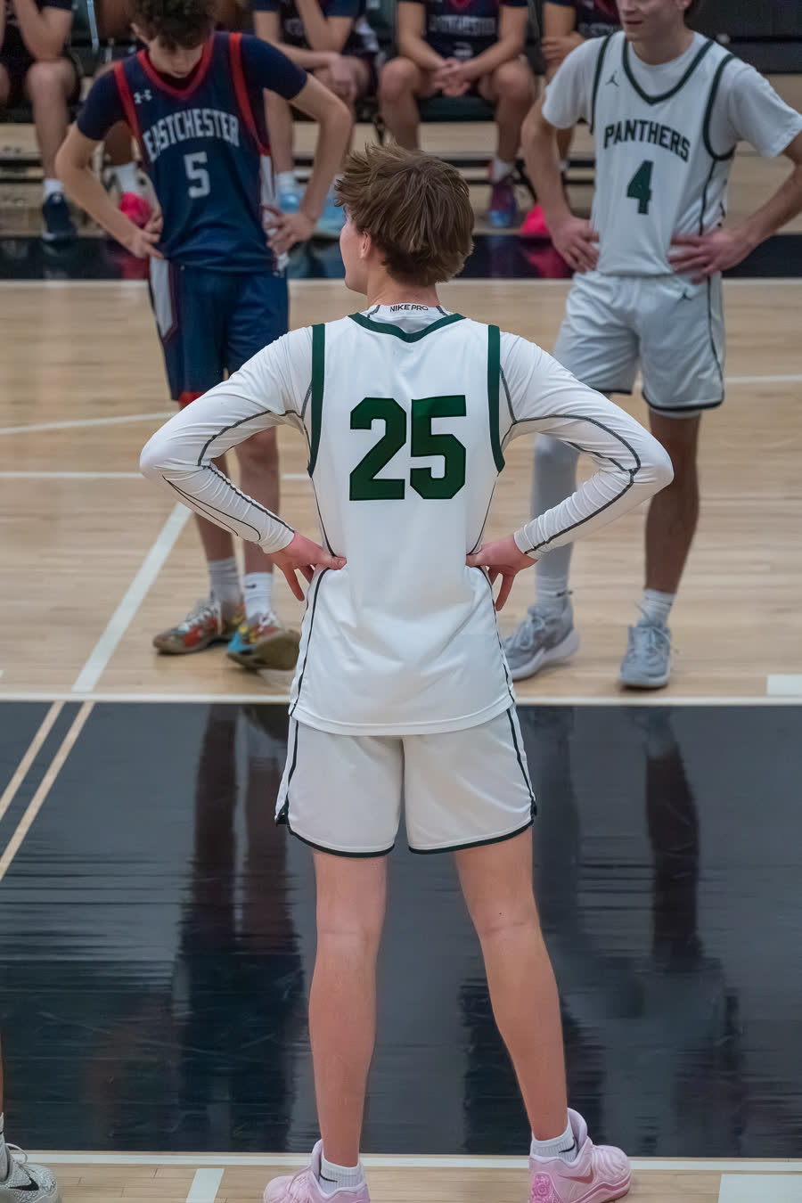 A player standing with hands on hips, back to the camera