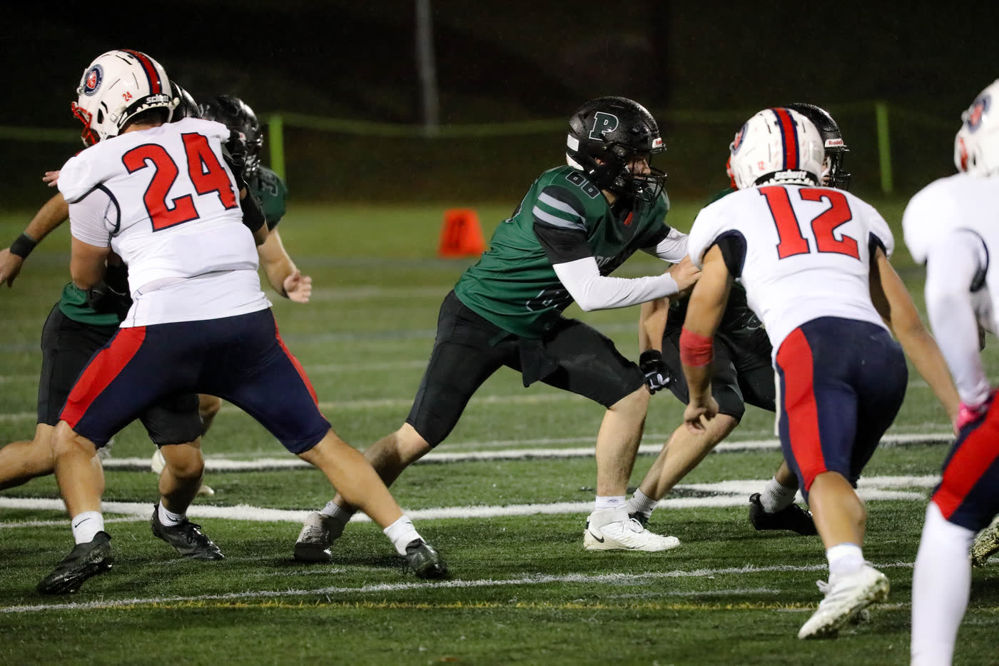 Proctor football line play during a night game